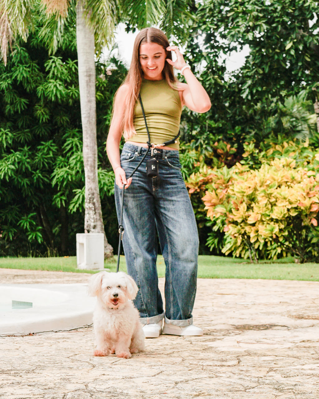 Woman walking fluffy white dog with leash outdoors, pet accessories Punta Cana