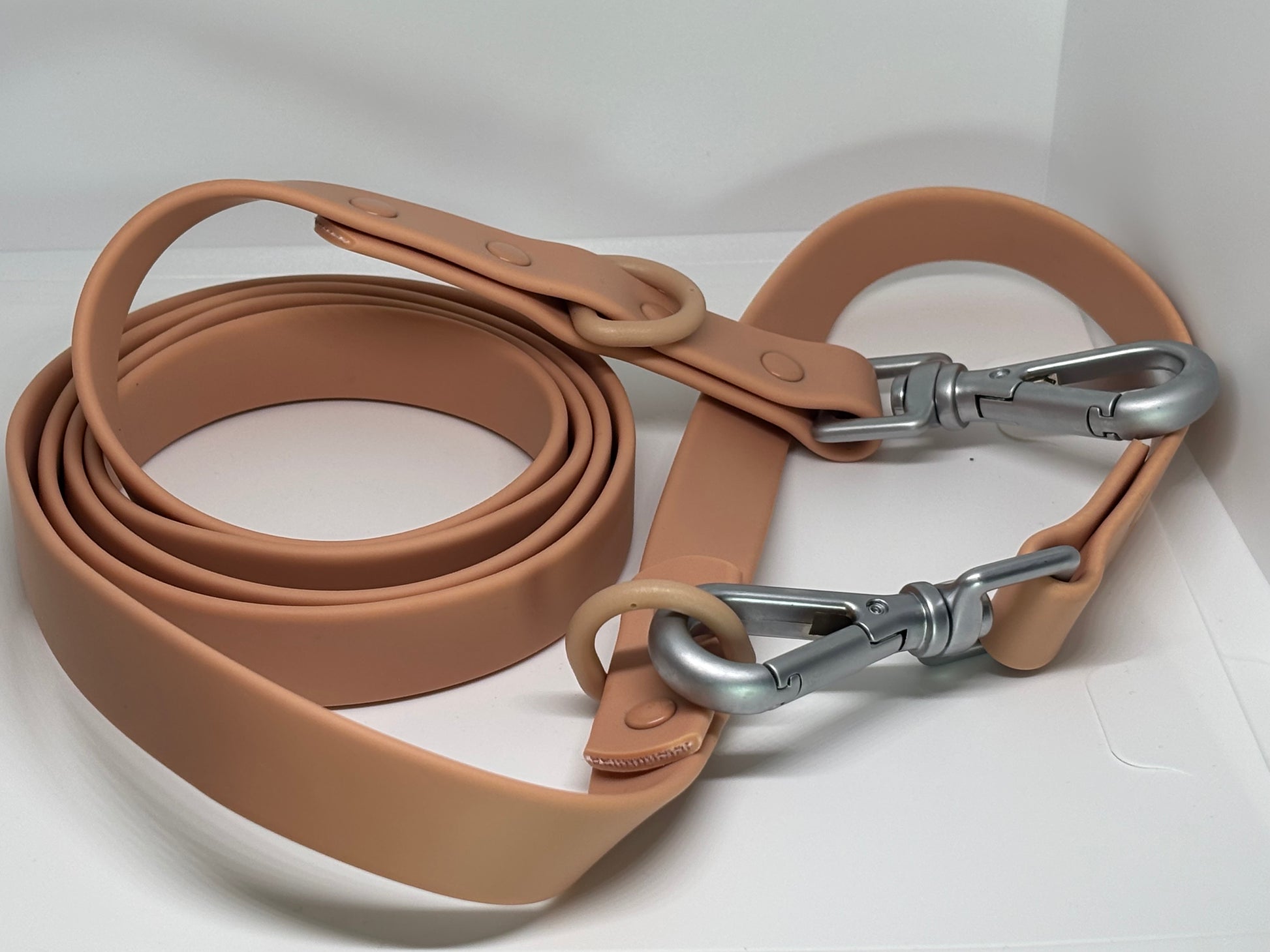 Beige silicone dog leash with metal clips for pet accessories display